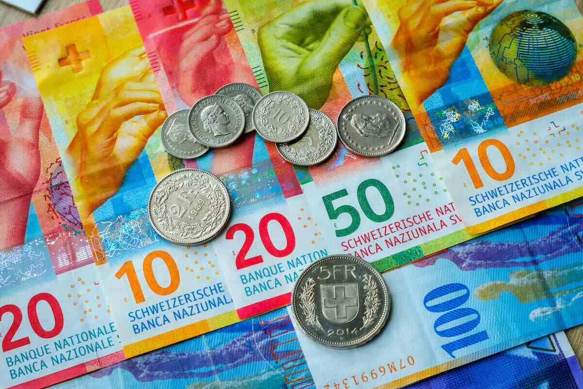 Swiss franc: colorful banknotes (10, 20, 50, 100) and coins of various denominations.