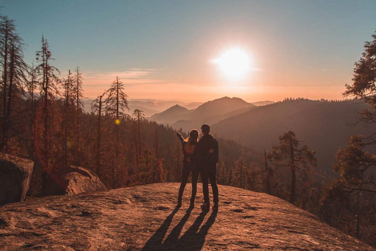 Autumn in Switzerland: two people enjoying mountains and trees in warm fall colors.