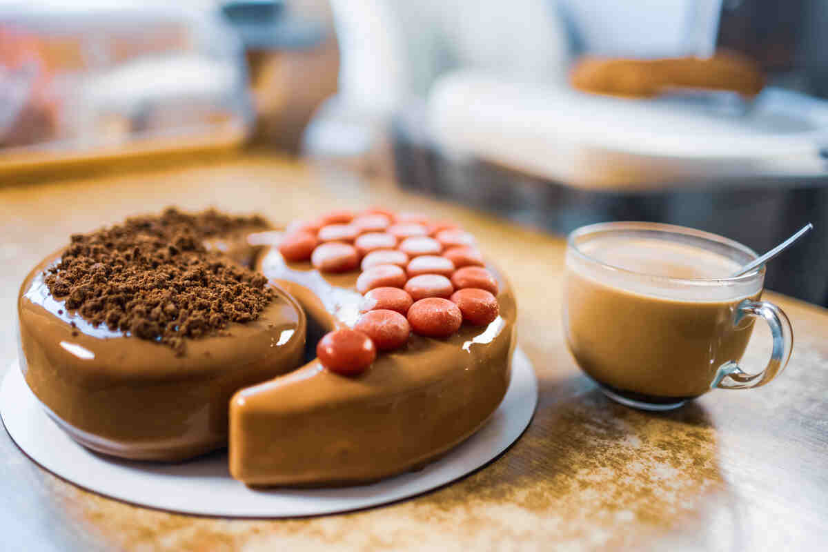 Dessert with caramel topping and a cup of coffee, served with a spoon