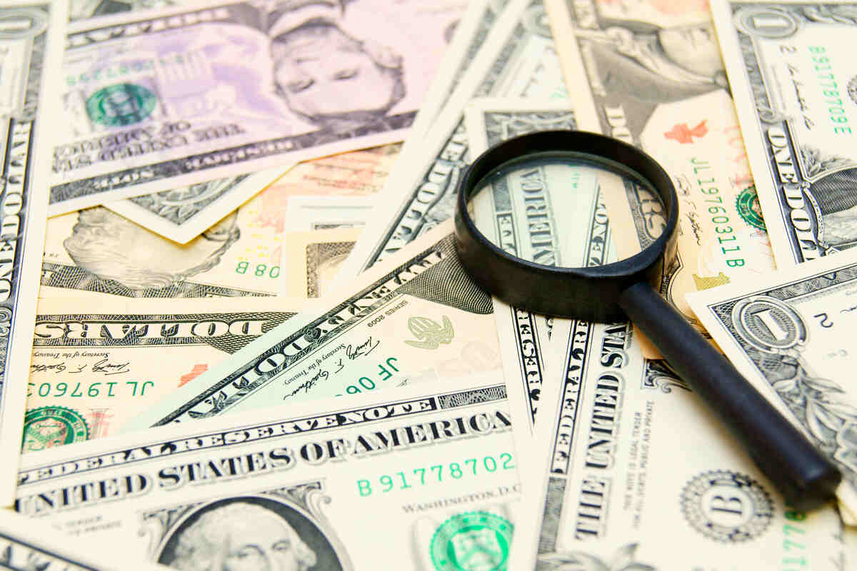 money dollars and magnifier