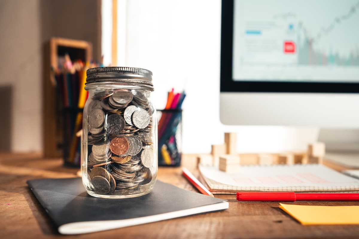 foreign leftover coins in a glass jar on the desk
