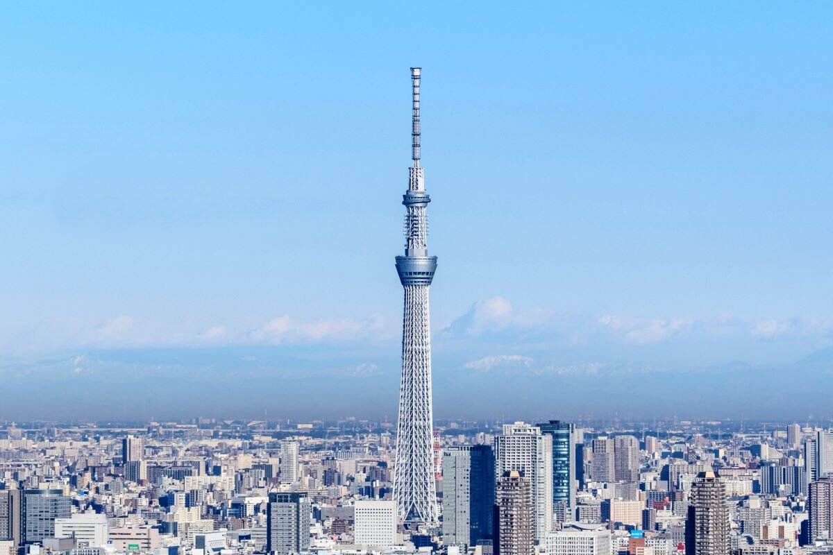 Tokyo Skytree dominates the skyline, surrounded by urban architecture under a clear blue sky